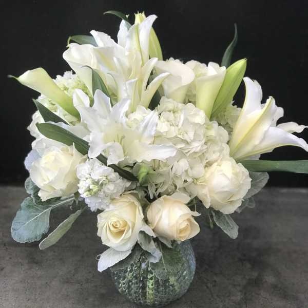 White floral bouquet in a textured glass vase