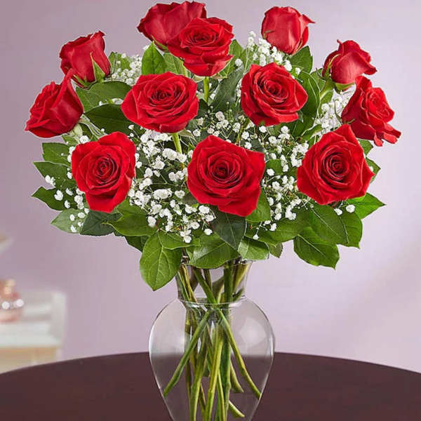 Bouquet of red roses and white baby's breath in a clear glass vase