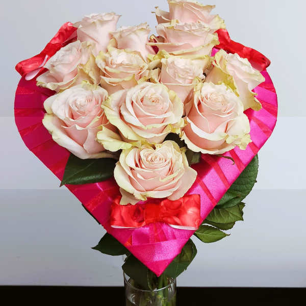 Bouquet of pale pink roses wrapped in bright pink paper