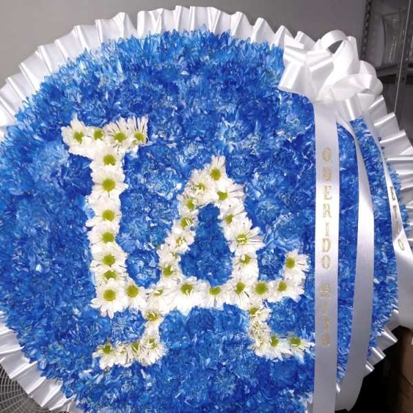 Blue floral funeral wreath with white daisy letters and ribbon
