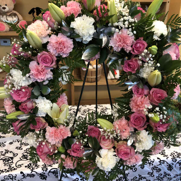 Pink and white floral wreath on a black easel
