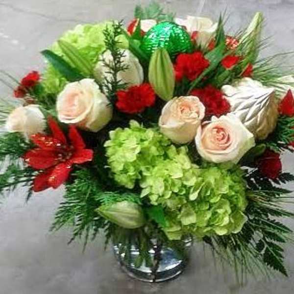 Bouquet of white roses, red flowers, and green hydrangeas in a vase