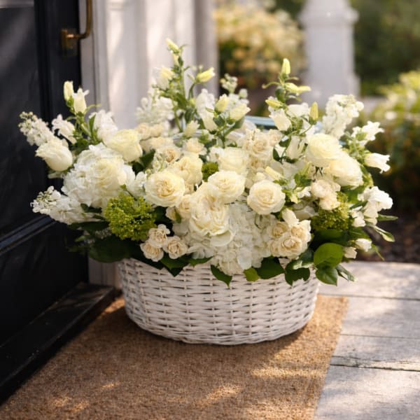 White floral arrangement in a white wicker basket