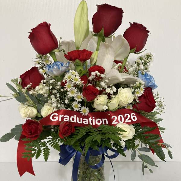 Red roses and white lilies in a glass vase with a graduation ribbon