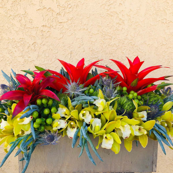 Bright tropical flower arrangement in a rectangular container