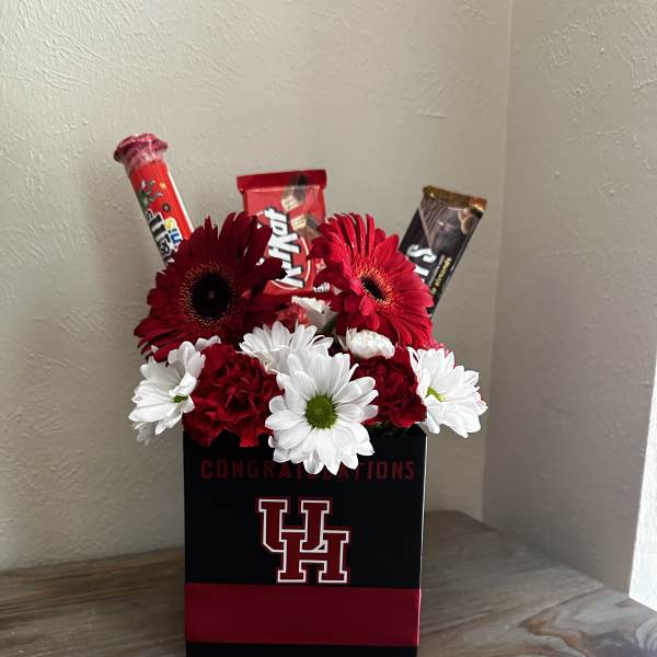 Red and white daisy arrangement in a black gift box with candy bars