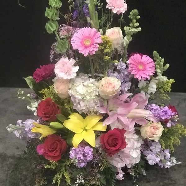 Tall mixed flower arrangement with pink, yellow, red, and lavender blooms