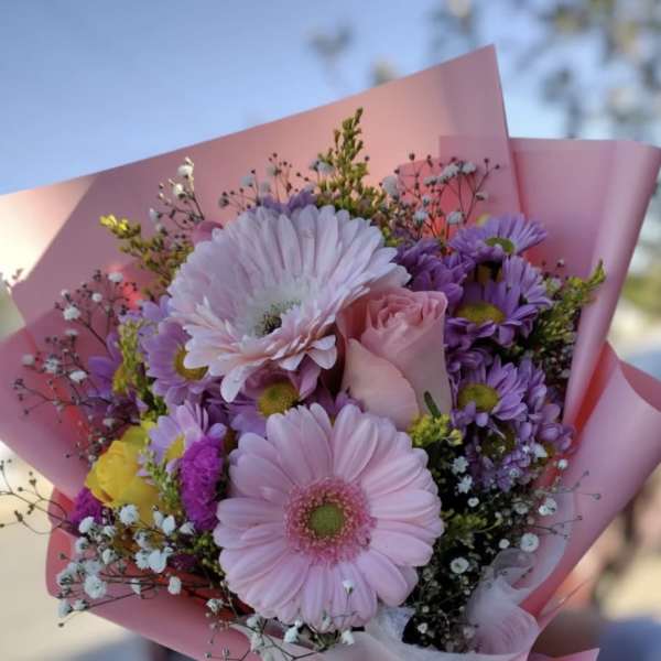 Pink and purple bouquet with gerbera daisies and a rose in pink wrap