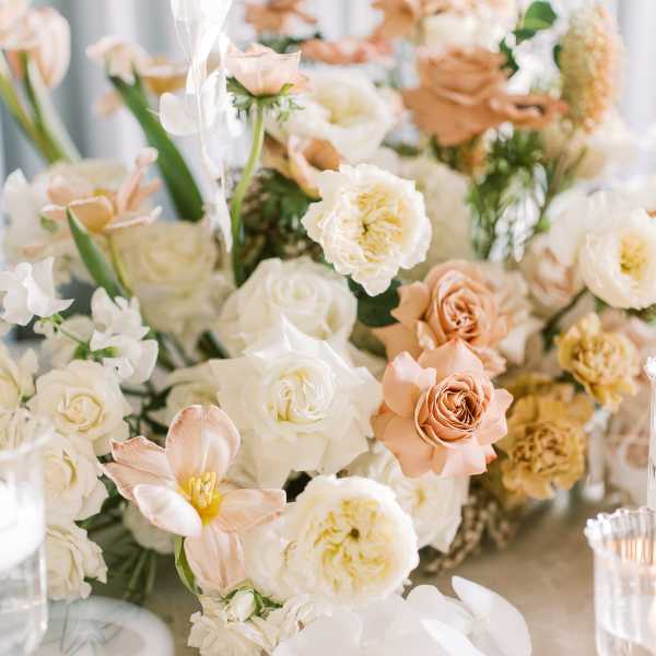 Soft peach and white floral centerpiece with orchids and roses