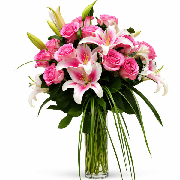 Pink roses and white lilies arranged in a clear glass vase