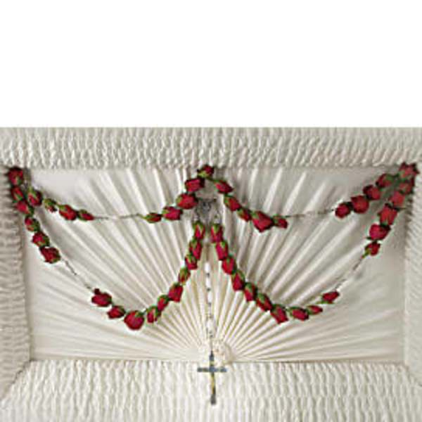 White funeral casket with red rose garland and cross