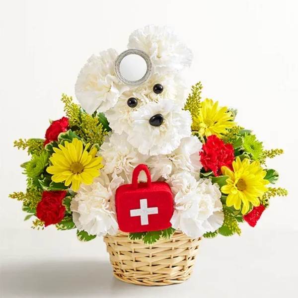 Teddy bear made of white flowers in a basket with red and yellow blooms