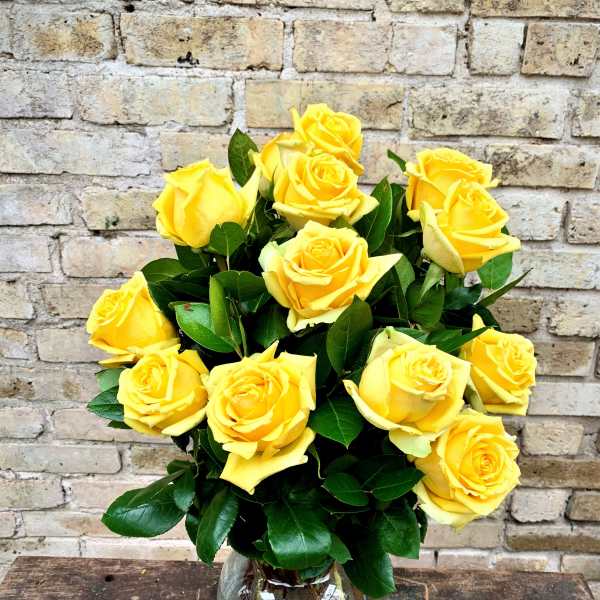 Yellow roses arranged in a clear glass vase