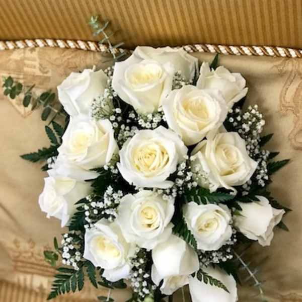 Bouquet of white roses with baby's breath and trailing greenery