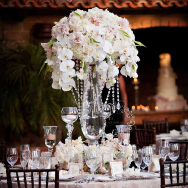 Tall white floral centerpiece on a decorated banquet table