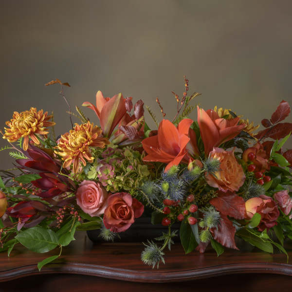Autumn floral arrangement with orange lilies, roses, and chrysanthemums