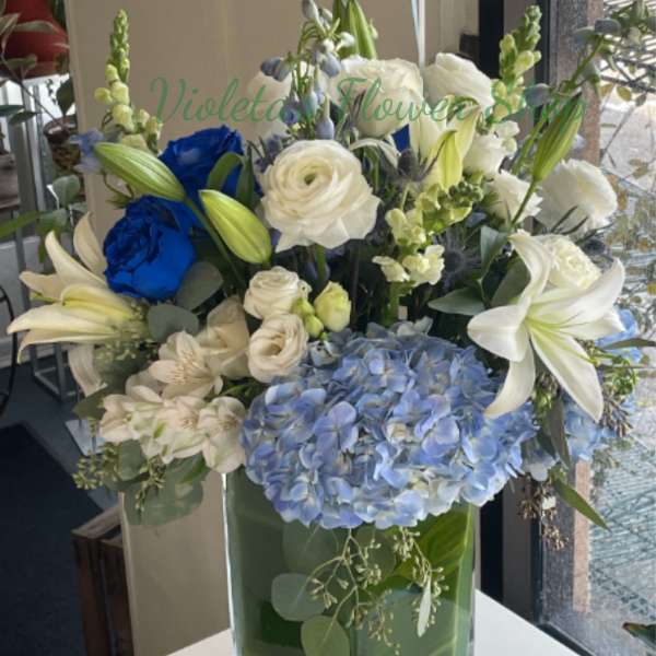 Blue and white floral arrangement in a clear glass vase