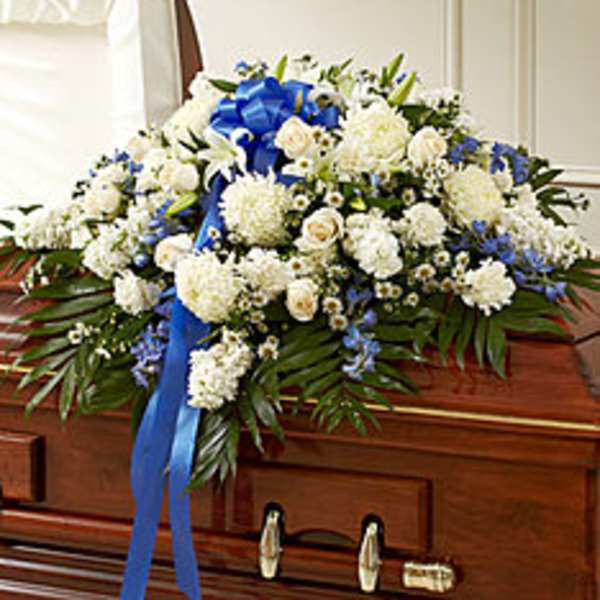 White floral casket spray with blue ribbon accents