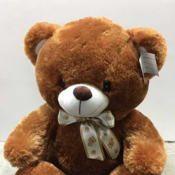 Large brown teddy bear with a ribbon bow