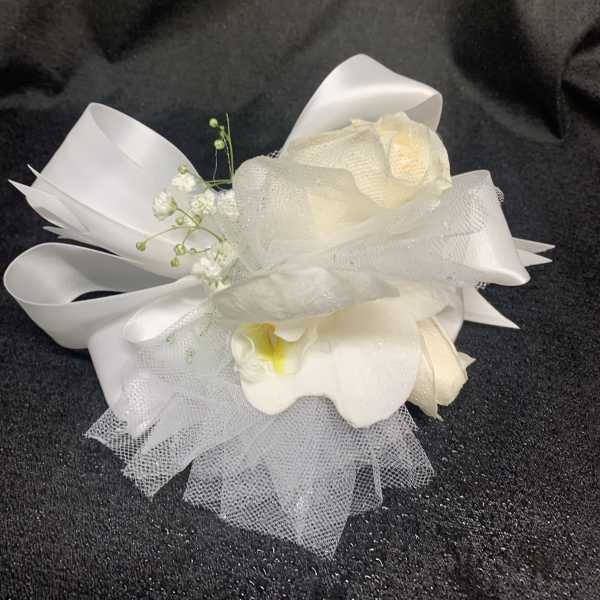 White floral wrist corsage with ribbon and tulle accents