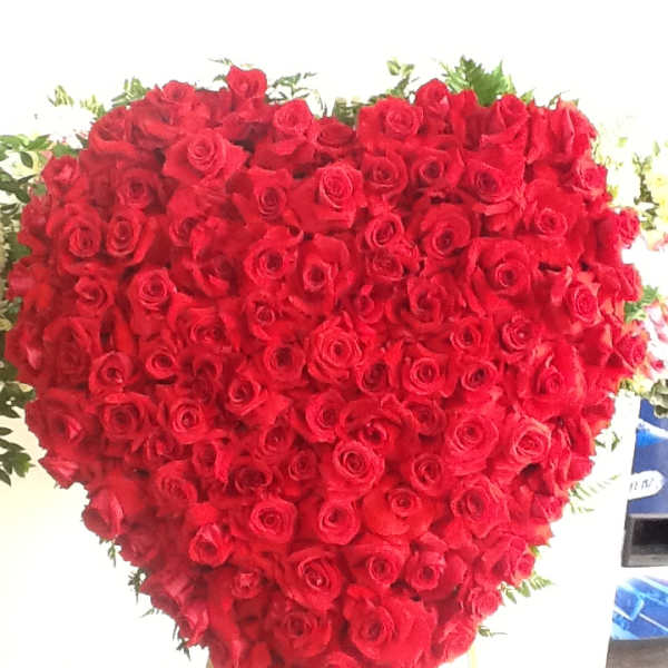 Heart-shaped arrangement of red roses on a stand