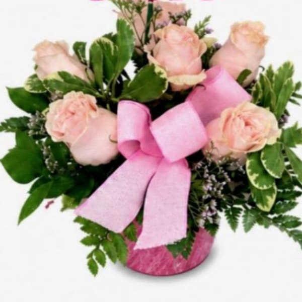 Pink roses in a pink vase with a large pink ribbon
