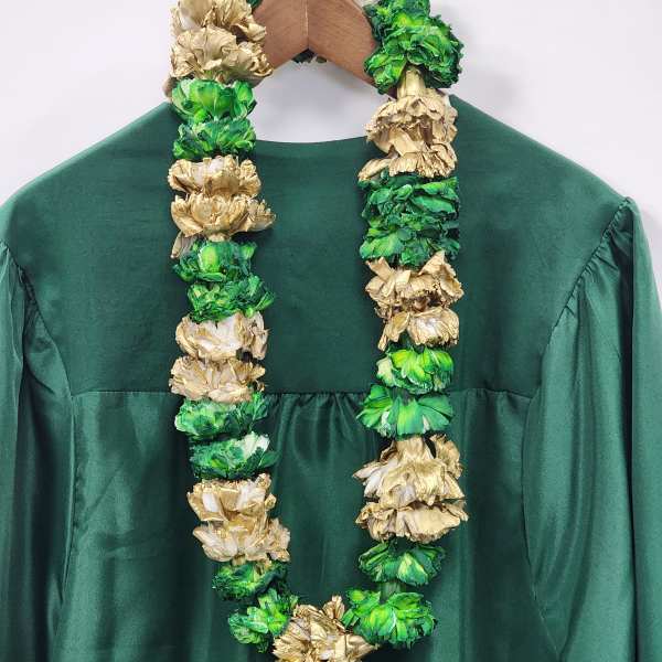 Green and gold floral lei draped over a dark green dress on a hanger