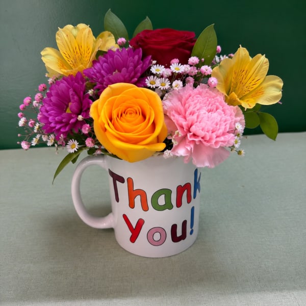 Mixed flower bouquet in a white mug that says Thank You