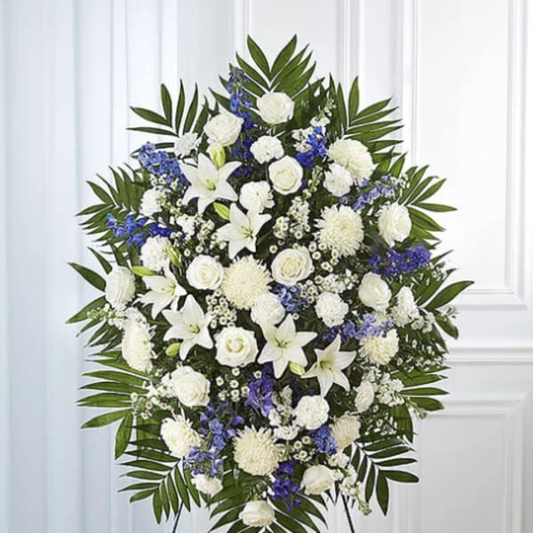 Standing floral spray of white and blue flowers on an easel