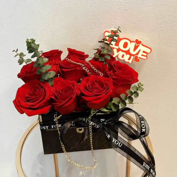 Red roses in a black gift box with a "Love You" topper