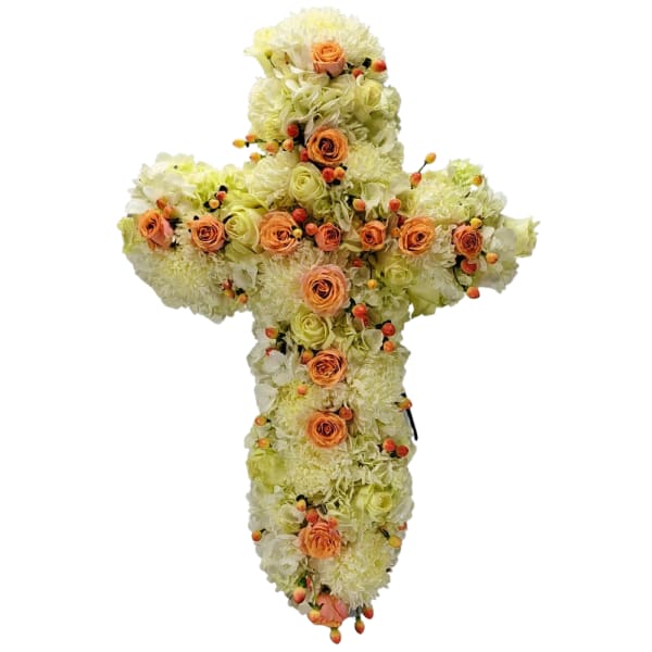 Cross-shaped floral arrangement with peach roses and pale blooms