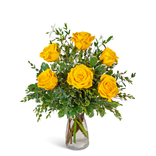 Yellow roses in a clear glass vase with mixed greenery