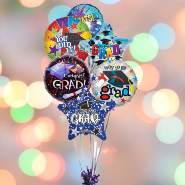 Cluster of graduation-themed balloons with a purple weight at the bottom