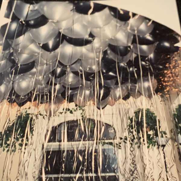 Cluster of black and silver balloons with long hanging ribbons