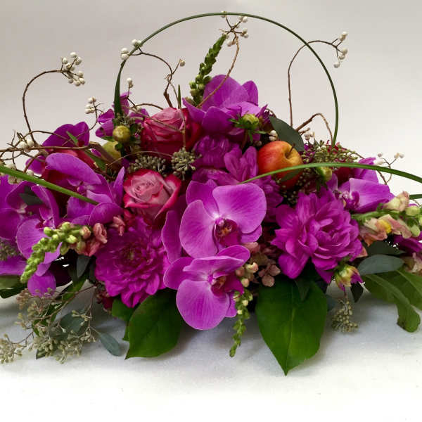 Purple orchid arrangement with apples and arched twigs