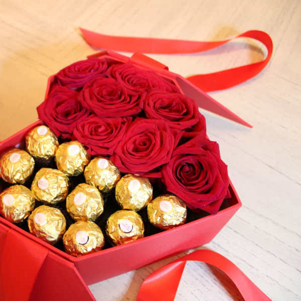 Red roses and gold-wrapped chocolates in a red gift box