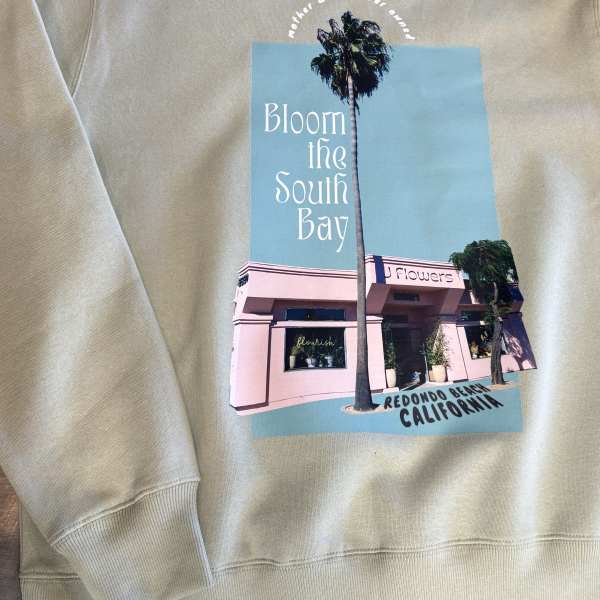 Beige sweatshirt with a printed flower shop graphic and palm trees