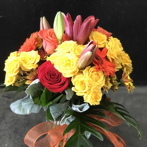 Bouquet of yellow and red roses with lilies and gerbera daisies