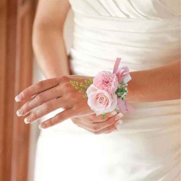 Bride wearing a pink floral wrist corsage