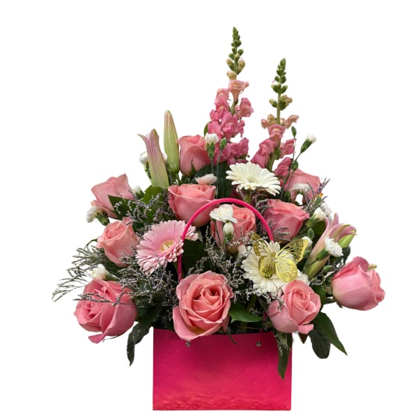 Butterfly kiss ' A rose arrangement in a clutch bag featuring 11 light pink roses, three gerberas, limonium, mini carnations, and stock.