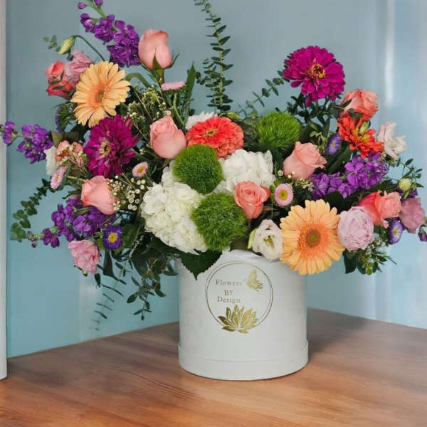 Colorful mixed flower arrangement in a white hat box