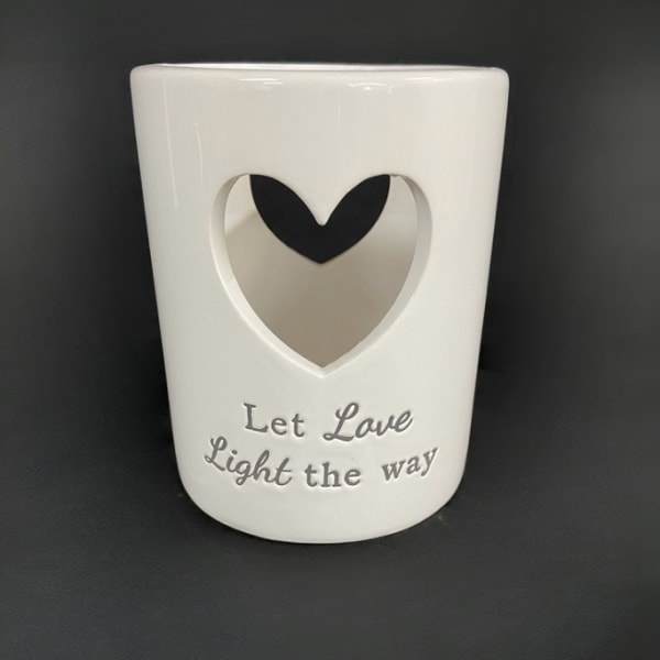 White ceramic candle holder with a heart cutout and "Let Love Light the way" text