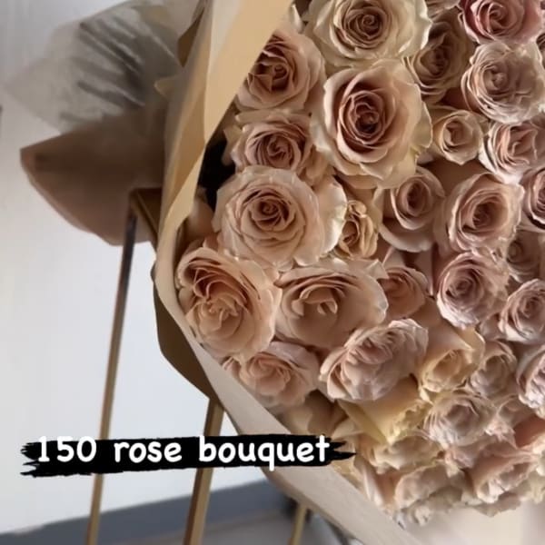 Large bouquet of blush roses wrapped in tan paper