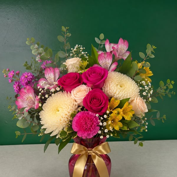 Bouquet of pink roses, chrysanthemums, and alstroemeria in a pink vase