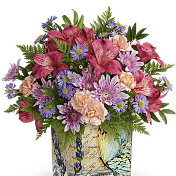 Mixed pink and purple bouquet in a butterfly-patterned square vase