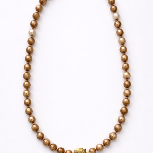 Gold beaded necklace on a white background