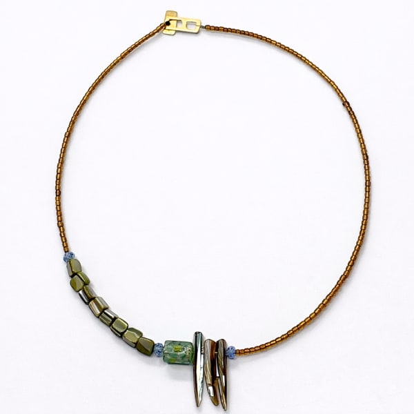 Beaded necklace with green and metallic beads on a white background