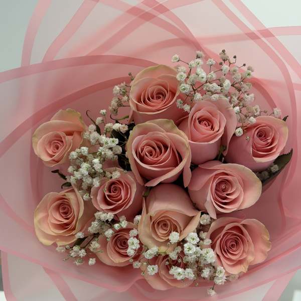 Bouquet of pink roses with white baby's breath in pink wrap