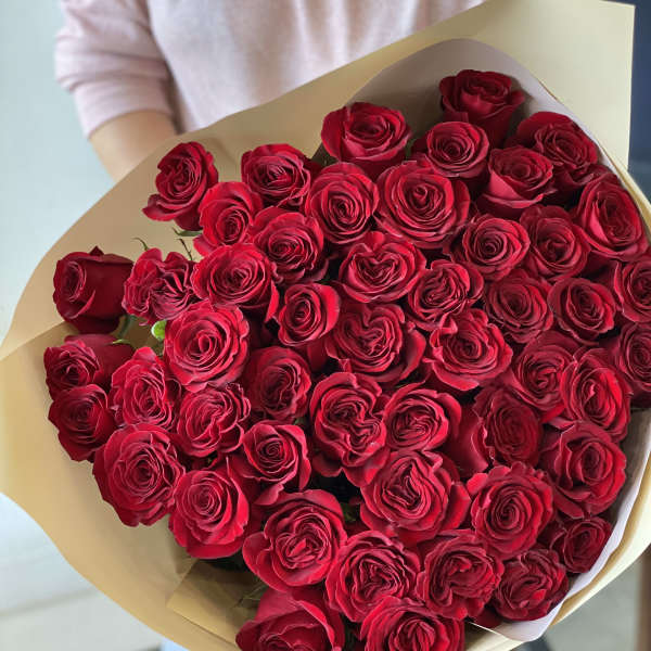 Large bouquet of red roses wrapped in beige paper