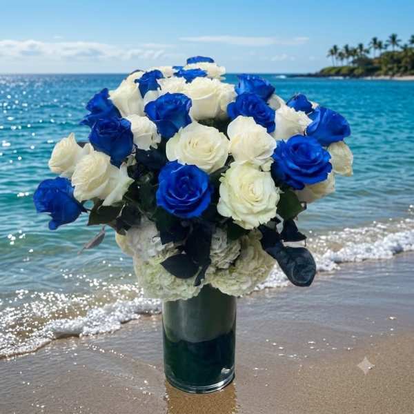 Blue and white rose bouquet in a glass vase on a beach